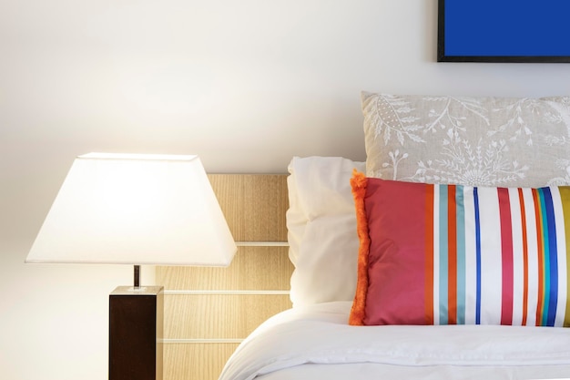 Detail of bedroom headboard with cushions lamp