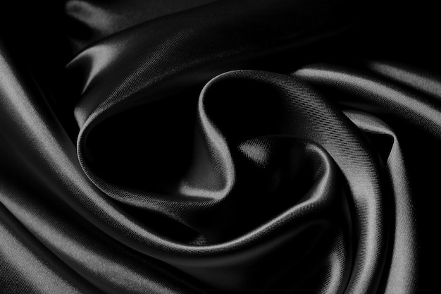 Photo detail of a black wavy silk fabric texture.