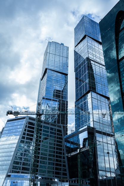 Detail blue glass building background with cloud sky