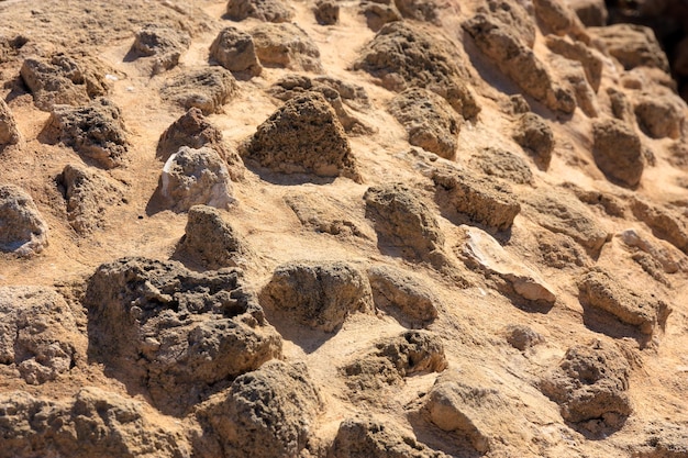 Detail of a brown stone old wall with different size of rocks.