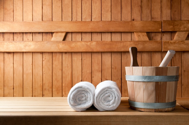 Foto dettaglio del secchio e asciugamani bianchi in una sauna