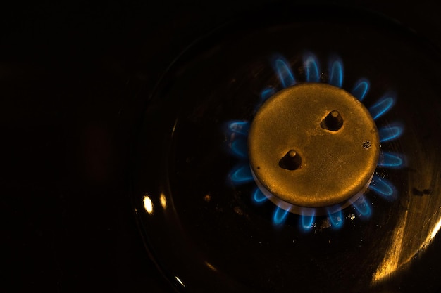 Detail of burning gas on the stove, rising gas prices an an impact of military conflict