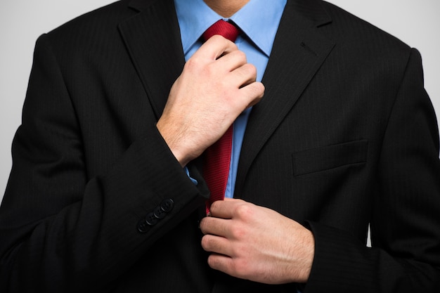 Detail of a businessman adjusting his necktie