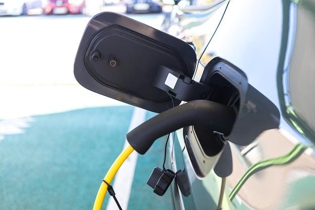 Detail of cable plugged into the electric car charging the battery Sustainability electricity load renewable energy