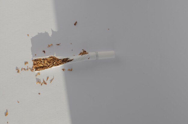 Photo detail of cigarettes on a white surface symbolizing the health risks and illnesses associated with smoking