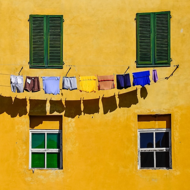 Detail of colorful yellow house walls windows and clothes