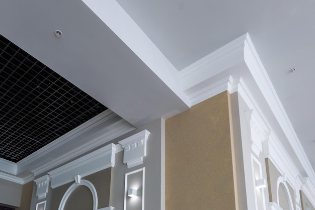 Detail of corner ceiling with intricate crown molding on column\
with spot light