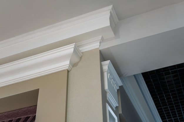 Detail of corner ceiling with intricate crown molding on column\
with spot light