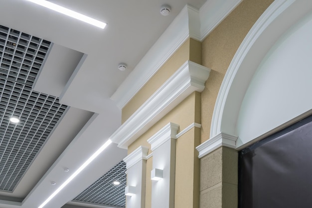 Particolare del soffitto ad angolo con intricata modanatura a corona su colonna con faretto