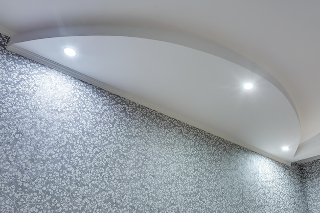 Detail of corner ceiling with intricate crown molding suspended\
ceiling and drywall construction in empty room in apartment or\
house stretch ceiling white and complex shape