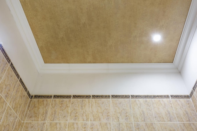 Detail of corner ceiling with intricate crown molding suspended\
ceiling and drywall construction in empty room in apartment or\
house stretch ceiling white and complex shape