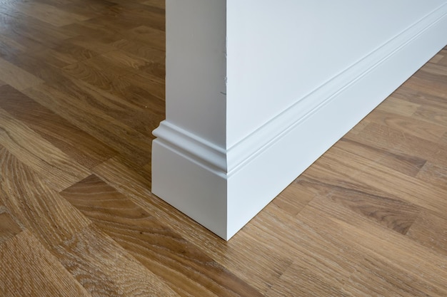 Detail of corner flooring with intricate crown molding and\
plinth