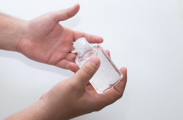 Foto detail dat van mannelijke handen een fles hydro-alcoholische gel klaar houdt om te worden gedesinfecteerd
