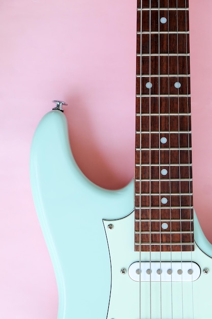 Detail of electric guitar on a pink surface