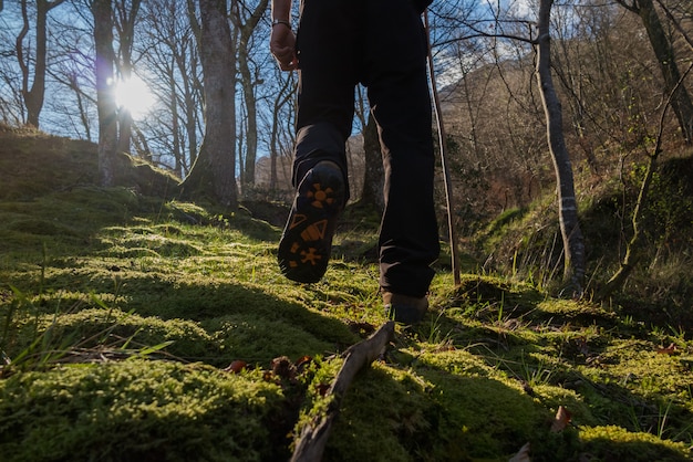 Foto dettaglio dei piedi che camminano sulla montagna al sole