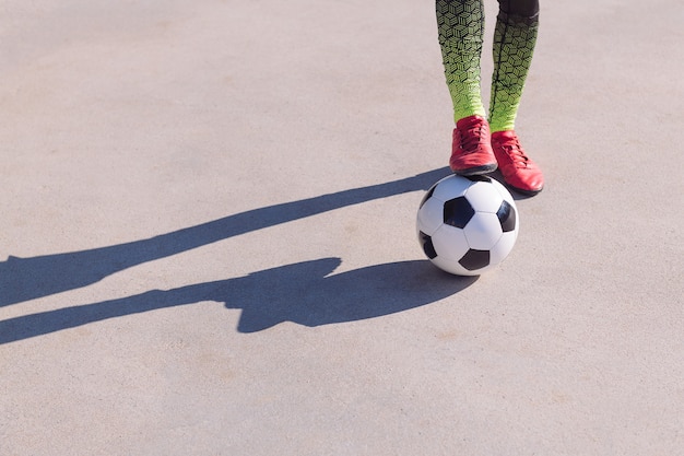 Detail of a foot on the ball on a concrete floor