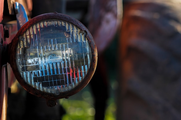 Detail of the front headlight of an old car in garage