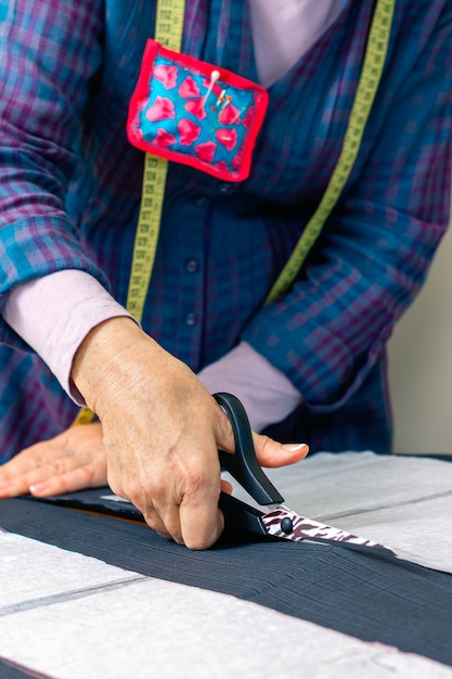 Detail of hands of dressmaker cutting a cloth to make a garment