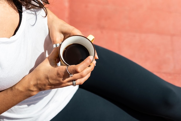 上から見た屋上でコーヒーを飲みながらの朝の女性の手の詳細