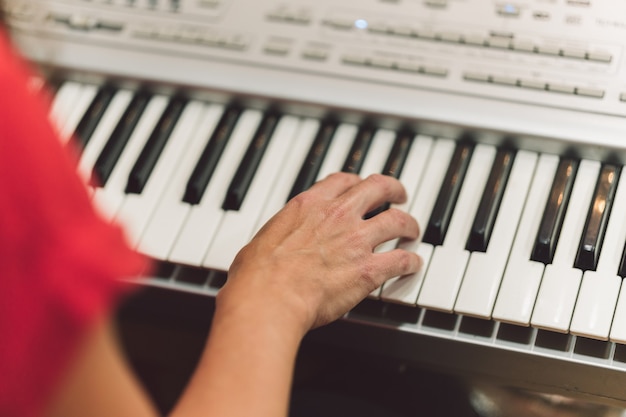 Detail of the hands of woman playing electronic piano