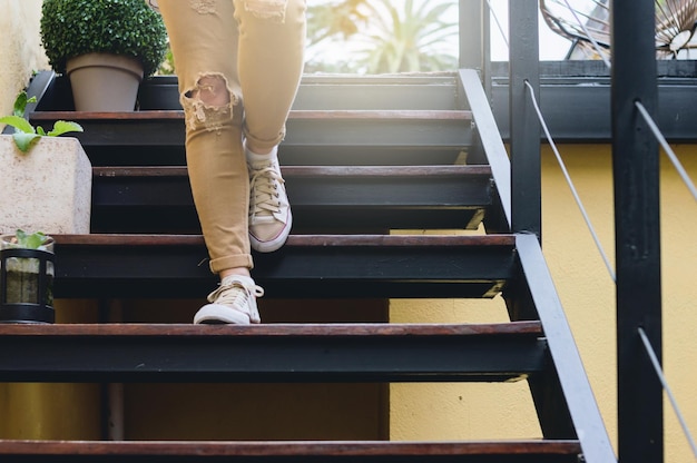 Photo detail on the legs of a young woman going down the stairs outdoors