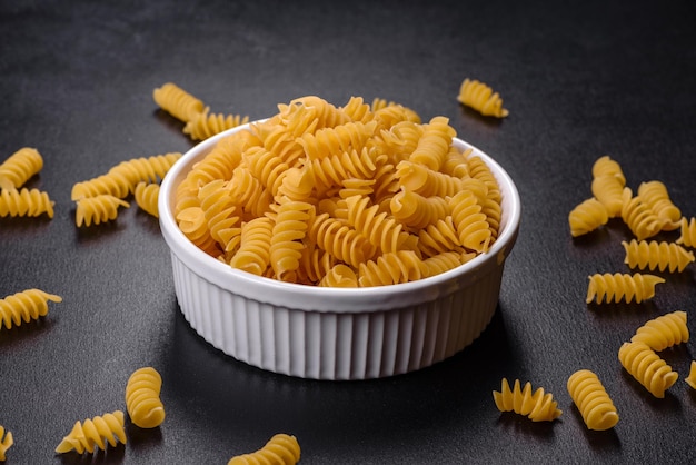 Detail of macaroni pasta useful as a background texture Dry pasta Top view on black background