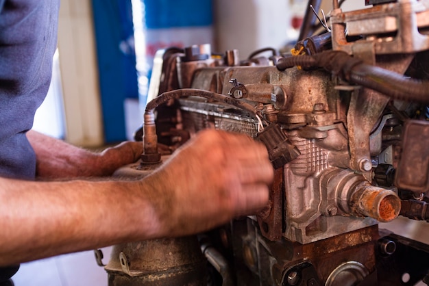 Деталь механика капитального ремонта двигателя автомобиля в мастерской