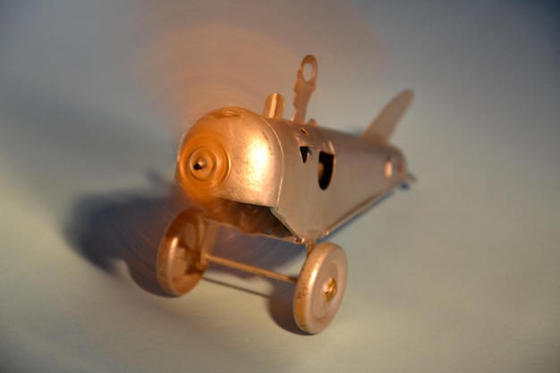Detail of a mechanical tin toy airoplane isolated on light blue\
background