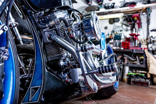 Foto dettagli su una motocicletta moderna in officina messa a fuoco selettiva dello scarico moto chiuso e selezionato focalizzato sul grande motore della motocicletta e altri dettagli