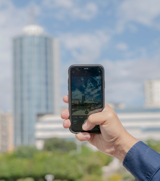 写真 携帯電話でパノラマ写真を撮る男性の手の詳細