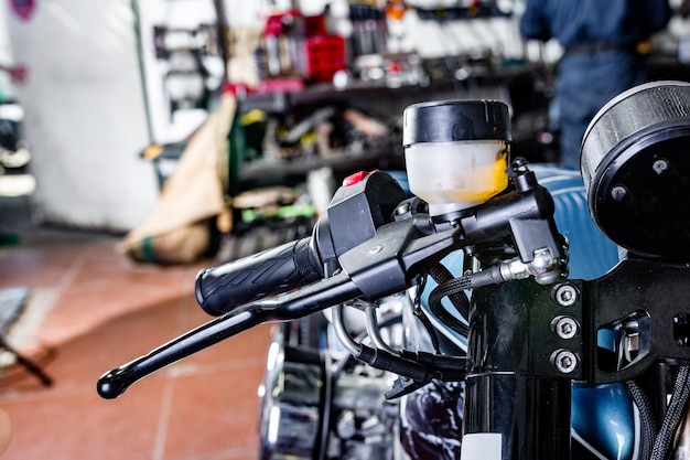 Detail op een moderne motorfiets in de werkplaats Selectieve focus van motorfietsuitlaat Gesloten en geselecteerd gericht op grote motorfietsmotor en andere details