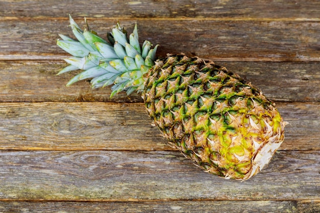 Detail of a organic pineapple on a wooden table in natural light