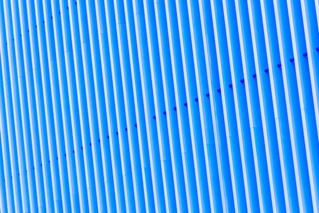 Detail of pattern striped metal facade for blue background