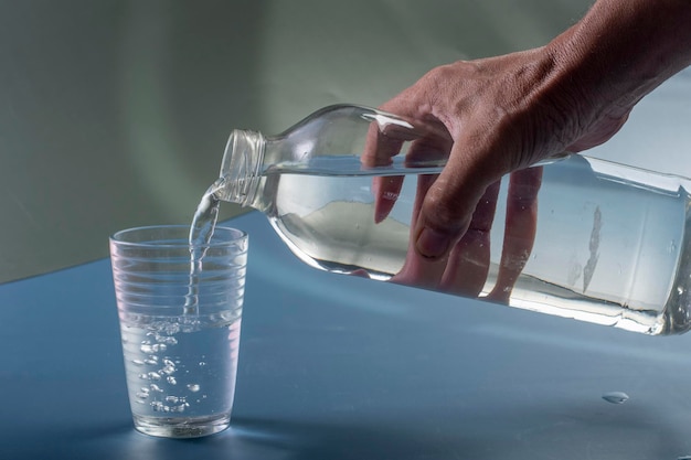 Деталь человека, наполняющего стакан концепции гидратации воды