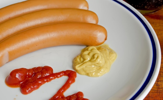 Detail of a plate with three hot dogs