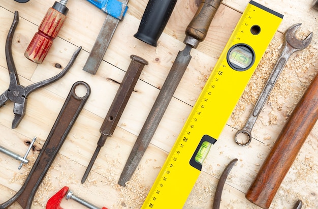 Detail of a set of joinery tools placed on a natural pine wood board. Work and DIY concept.