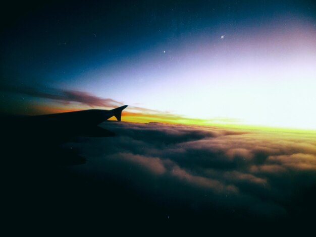 Foto immagine dettagliata dell'ala di un aereo contro il paesaggio nuvoloso e il cielo