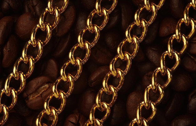 Photo detail shot of golden chain on roasted coffee beans
