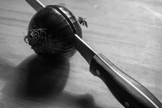 Photo detail shot of knife and onion on table