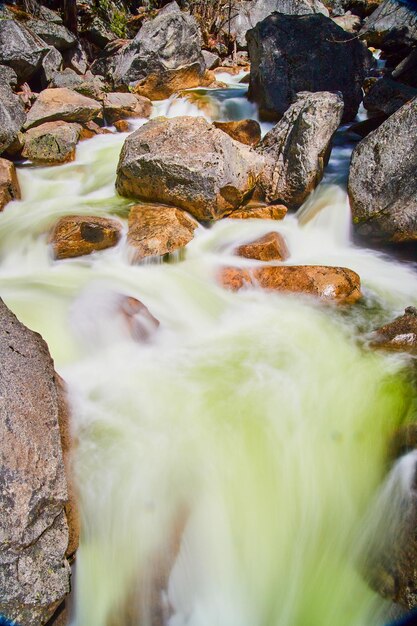 바위 위에 강을 통해 쏟아지는 청록색 물의 세부 사항