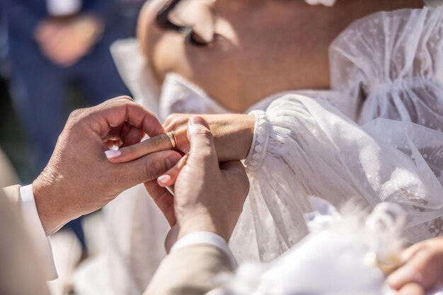 Foto detail van bruidegom die een ring aan de vinger van de bruid legt