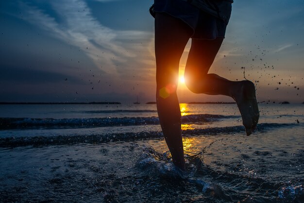 Detail van de benen van de vrouw lopen door de zee