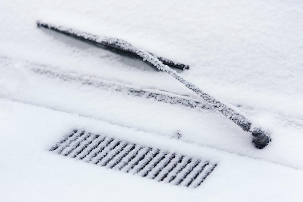 Detail van de voorruit van de auto met sneeuwverwijdering is bedekt met rijp