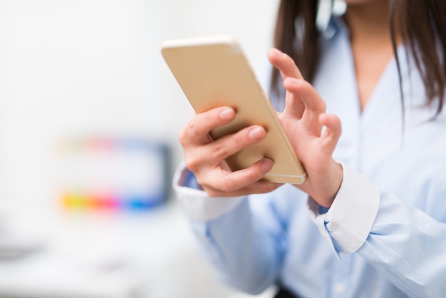 Detail van een bedrijfsvrouw die haar mobiele telefoon met behulp van