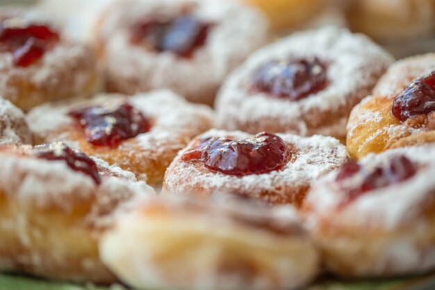 Detail van een bord donuts gevuld met jam en bedekt met suiker.