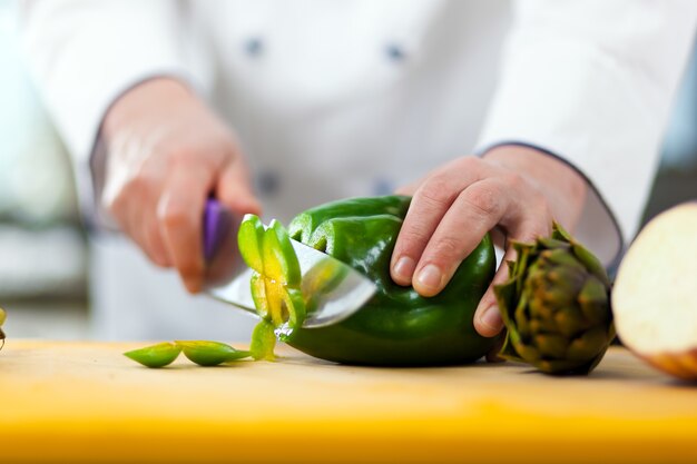 Detail van een chef-kok aan het werk in zijn keuken