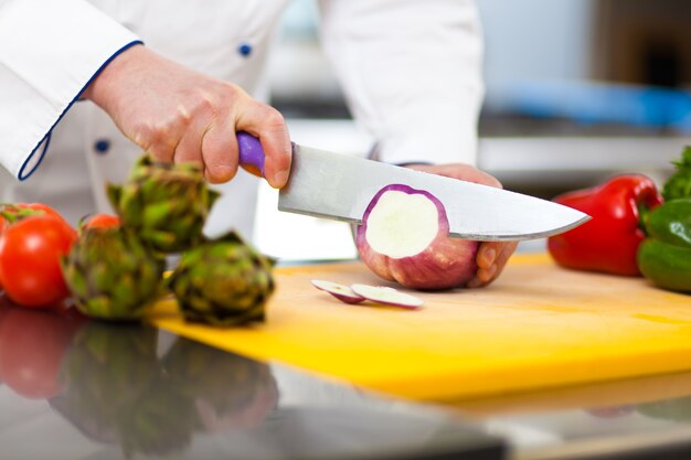 Detail van een chef-kok aan het werk in zijn keuken