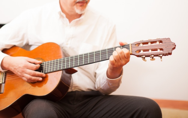 Detail van een man die een gitaar speelt