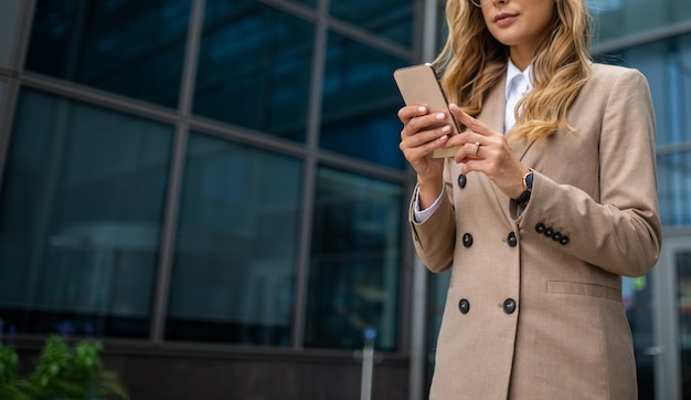 Detail van een zakenvrouw die haar mobiele telefoon gebruikt