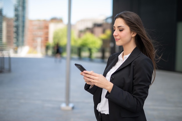 Detail van een zakenvrouw die haar smartphone gebruikt